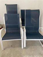 Three black mesh outdoor chairs with white metal frames viewed from the front.