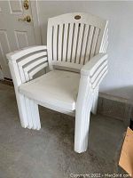 Single white resin outdoor chair from Hartman Prestige Selection showing armrests, slatted back, and some wear/dirt.