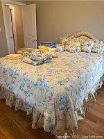 Bed fully made with floral upholstery and linens, showing overall style and condition