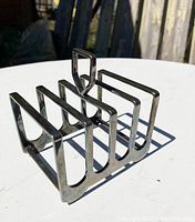 Photo of Elkington silver plate toast rack showing five slot design and Art Deco handle detail.