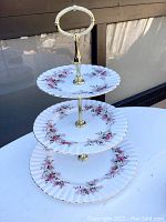 Full view of the assembled 3-tier bone china cake stand showing the tier sizes, pattern and gold accents.
