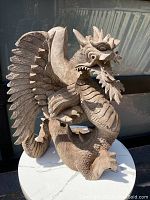 Full view of the wooden dragon from the side, showing detailed carving work and overall shape.