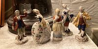 Group view of all five vintage Italian mini figurines, highlighting their clothing details and colors, arranged on a textured surface.