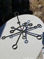 Top-down view of the metal candle holder showing the radial symmetrical design with eight circular holders around a central vertical support.
