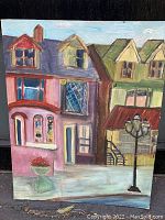 Full view of the unframed original painting showing colorful houses and street lamp.
