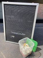 Full view of vintage letterboard with black felt and silver frame, standing upright, with the plastic container of letters in front.