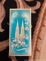 Closed original turquoise box with cathedral and floral design on front for No. 4711 Eau de Cologne.