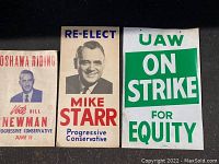 Three vintage political and union election signs displayed on a flat surface.