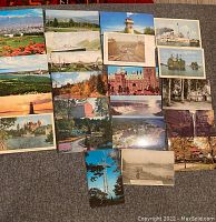 Top view showing 24 vintage postcards with various Canadian landscapes, cities, lighthouses, and historic sites, colorful and black and white images.