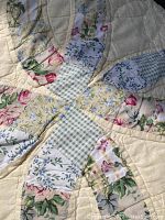 Close-up view of patchwork floral design with yellow background.