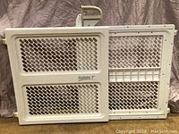 Full view of expandable Safety 1st baby gate showing white plastic mesh panels.