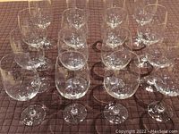 Top down view showing all 16 Spiegelau Cabernet Sauvignon wine glasses arranged in rows on a quilted cloth.