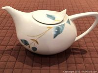 Side view of Gluckstein Home Serena porcelain tea pot showing leaf motif decoration and unique lid design