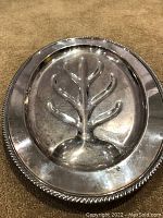 Image showing close-up view of the silver plated serving tray's ornate edge and dripping channels with visible aging wear and use marks.