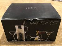 Photo of the original black box packaging labeled 'Bohemia' and 'Martini Set', depicting the pitcher, stirring rod, and martini glasses