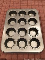 Top view of the Baker's Secret mini cupcake tray showing 12 cup molds.