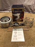 Complete Williams Sonoma fondue set pieces arranged with original box in background