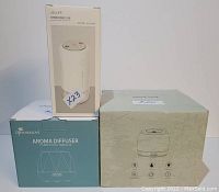 Photo of all three diffuser and humidifier boxes: Jisulife dual spray humidifier, DiffuserLove aroma diffuser, and stalking essential oil diffuser.