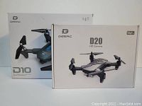 Photo showing the boxed Deerc D10 and D20 drones with packaging highlighting HD camera features and foldable designs.