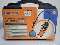 Photo of the Elitech ILD-200 infrared refrigerant leak detector packaging placed on top of a black carrying case showing product name, model and specifications.