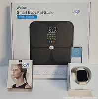 Photo showing Wellue Smart Body Fat Scale FI2016LB packaging, ZKCREATION fitness tracker box and wristband, and SoundPeats Air3 earbud box