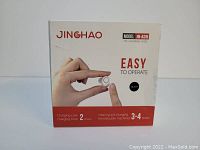 Front of box showing a hand holding the hearing aid. Brand Jinghao, model JH-A39, notes charging time 2 hours and usage time 12 hours.