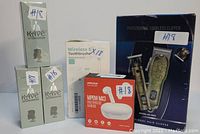 Photo showing MPOW MX3 wireless earbuds box, wireless electric toothbrush box, three bottles of Kv The Classic Masculine beard shampoo, and a professional cordless hair clipper box.