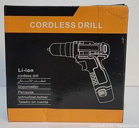 Photo of the boxed cordless drill showing packaging with product drawing and multilingual labeling.