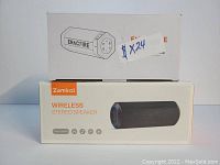 Photo showing boxed Enacfire Soundtank speaker on top of boxed Zamkol Wireless Stereo speaker