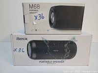 Boxed M68 Portable Speaker and Rienok Portable Speaker boxes stacked, with both showing brand/model and features.