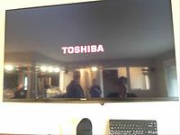 Front view of mounted Toshiba TV displaying brand logo