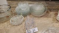 Various clear glass bowls, plates, and glasses arranged together on a surface