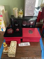 Multiple perfume sets including Drakkar Noir, Hypnotic Poison, and Madame Rochas on a table.