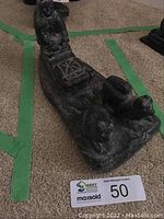 Full view of the soapstone sled sculpture on carpet, showing the human figure seated in the sled and dogs at the front.