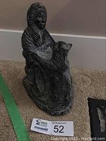 Front angled view showing figure in parka sitting with wolf beside