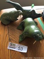 Group of three stone animal figurines on wood surface