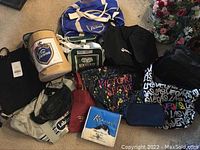 Large assortment of tote bags featuring Wil Vienna beer, Victoria's Secret, Kootenay and Labatt branding, various colors and styles