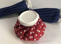 Three ice bags shown standing, two large blue and one smaller red with white stars, all with white screw lids.