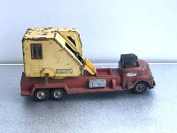 Side view of antique diecast toy truck with notable paint wear and detailed cab structure