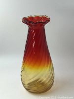 Full view of the vase showing amberina gradient from amber to rose red with swirl pattern and ruffled rim.
