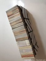 Stack of approximately 400 sports trading cards bundled and fanned out on white surface.