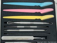 Plastic and stainless steel blackhead removal tools arranged in foam insert