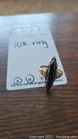 Front angle view of vintage marquise hematite ring set in 10k gold band showing front and side details of gold work and stone setting.