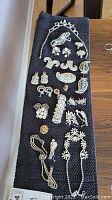 Black towel displaying full assortment of rhinestone jewelry pieces