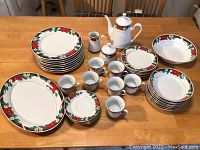 Wide view of all china pieces arranged on table to show set completeness and pattern details.