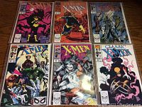 Six Marvel X-Men Classic comic books displayed on table, each in plastic sleeve showing wear from use and storage.