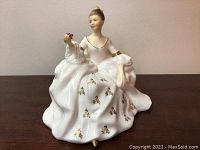 Front view showing the finely detailed face and dress with floral patterns and gold accents.