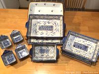 Set of three rectangular ceramic baking dishes with blue floral patterns, metal racks, and four small salt and pepper shakers