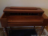 Front view of the fold-top desk with lid open showing compartment sections