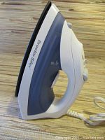 Side view of the Proctor Silex electric iron showing the handle, control knobs, and power cord.